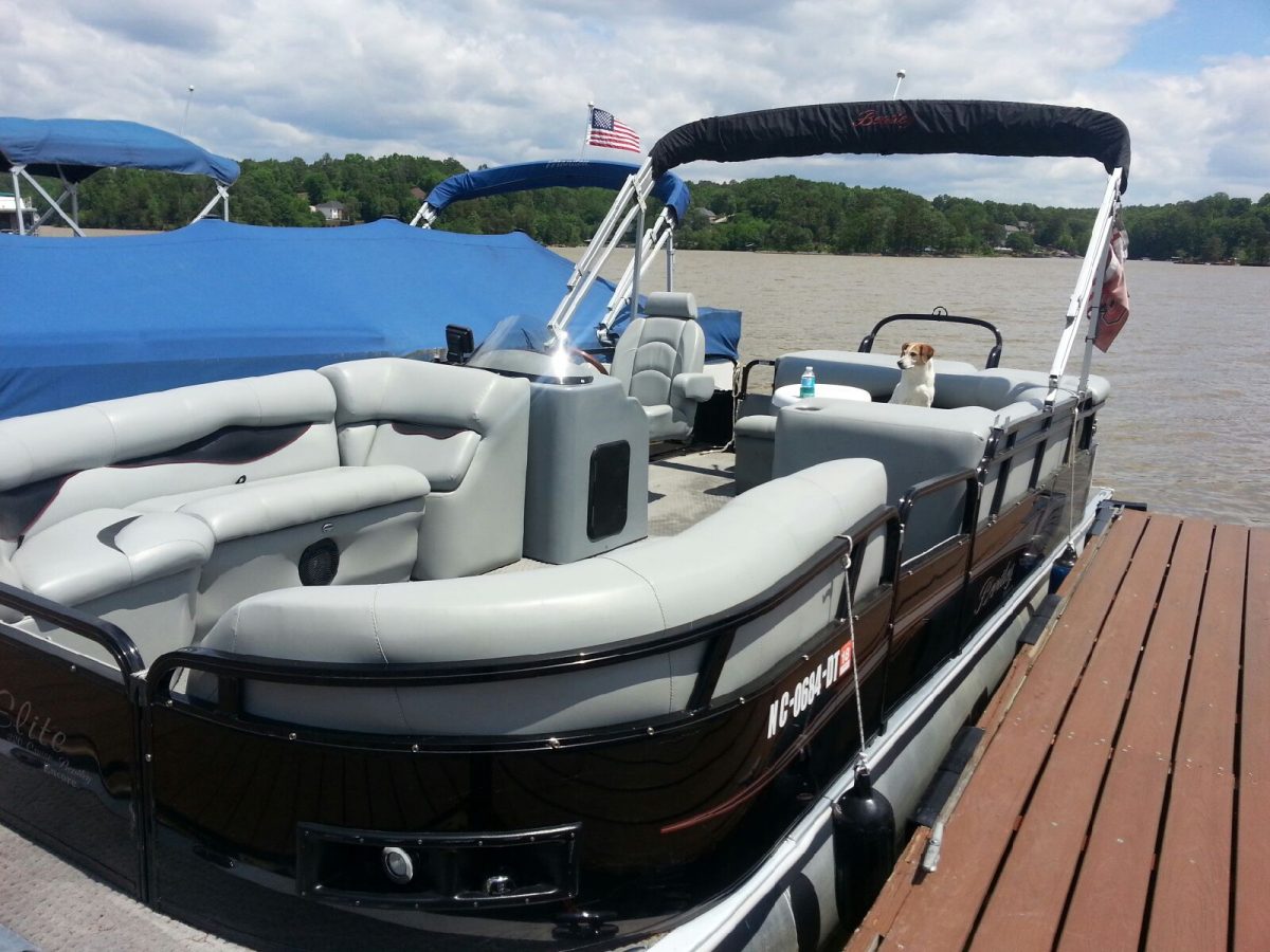 A boat is parked on the dock with people in it.